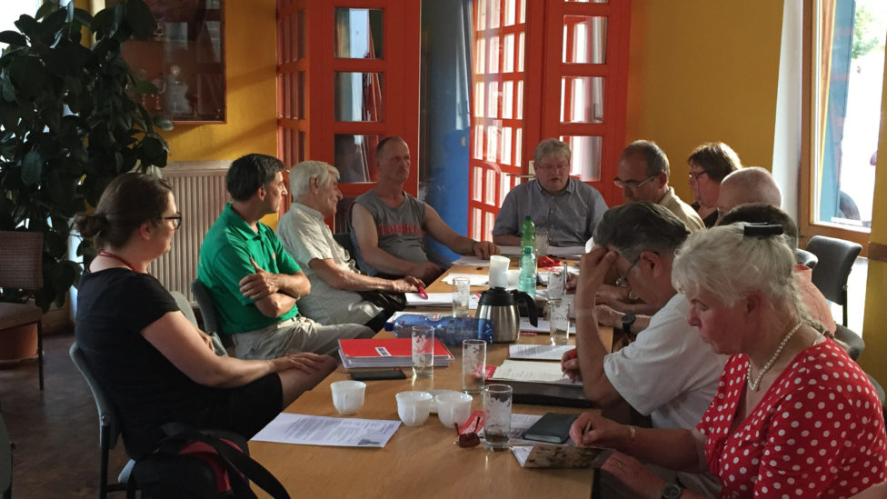 Anja Mayer und eine Gruppe Menschen sitzen an einem langen Tisch