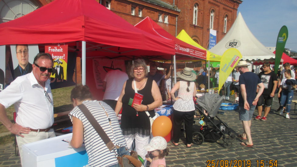 Stefan Ludwig und zwei Frauen stehen an einem Infostand