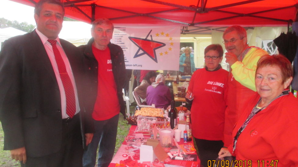 Roter Pavillon und Infotisch mit Material, um den mehrere Personen stehen