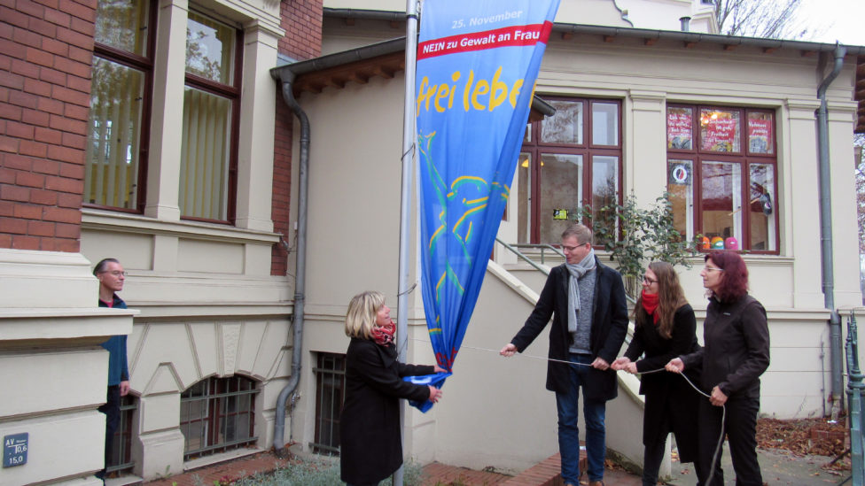 Kathrin Dannenberg, Sebastian Walter, Anja Mayer und Diana Golze hissen gemeinsam die Flagge der Organisation Terre des Femmes mit der Aufschrift "Frei leben – ohne Gewalt"