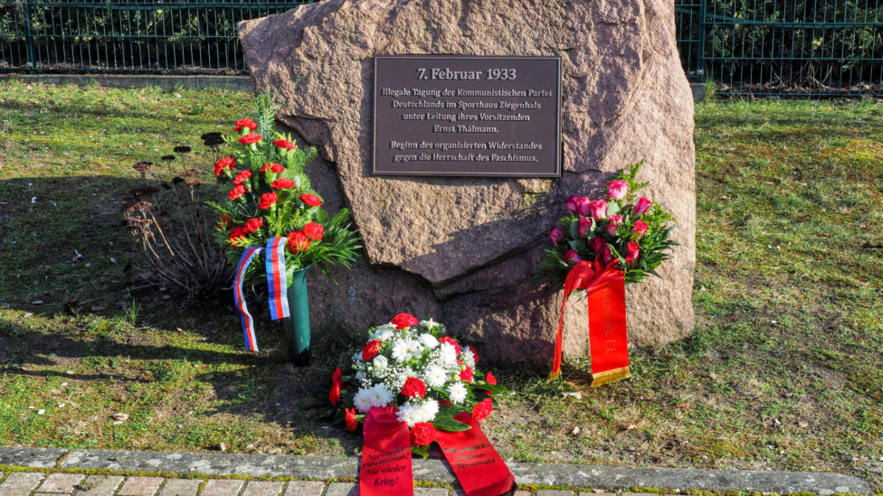 Blumengebinde mit Schleifen am Ernst-Thälmann-Gedenkstein in Ziegenhals