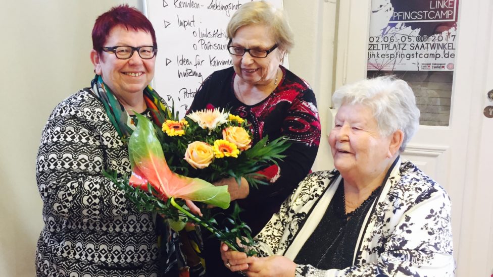 Bettina Fortunato und zwei weitere Frauen halten einen Blumenstrauß