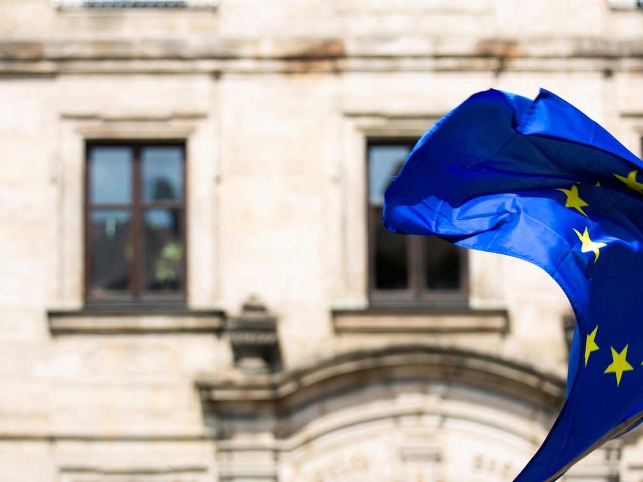 Europaflagge im Wind vor Häuserwand